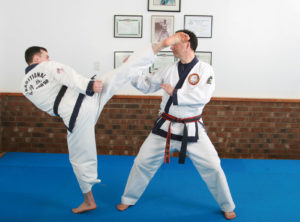 Mr Marsh performing a roundhouse kick with Master Marsh